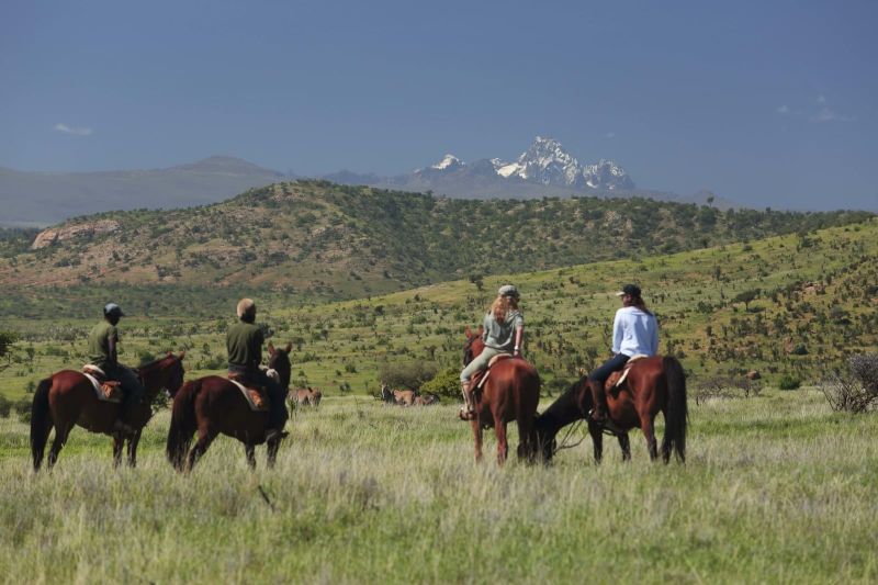 4 horse riders in Borana lodge facing the mountains
