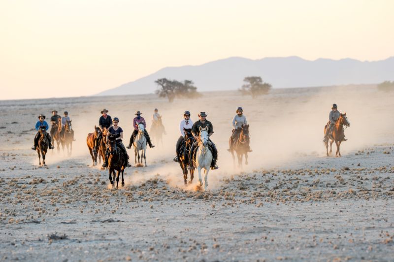 A group of people horse riding in the Damara Elephant Trail Horses, Namibia